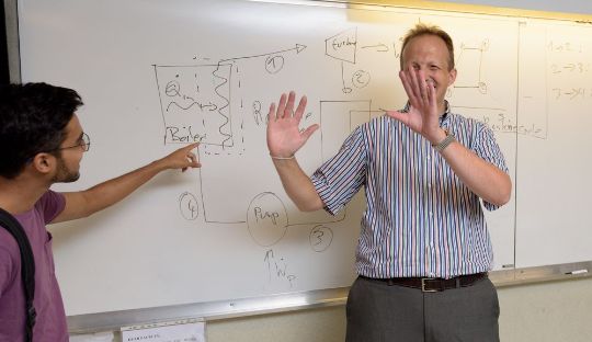 Professor and student laughing while teaching
